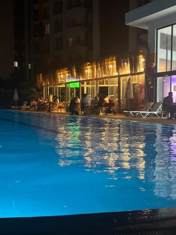 a large swimming pool at night with a hotel at 2 bedroom in an sexy compound with Balcony in Antalya