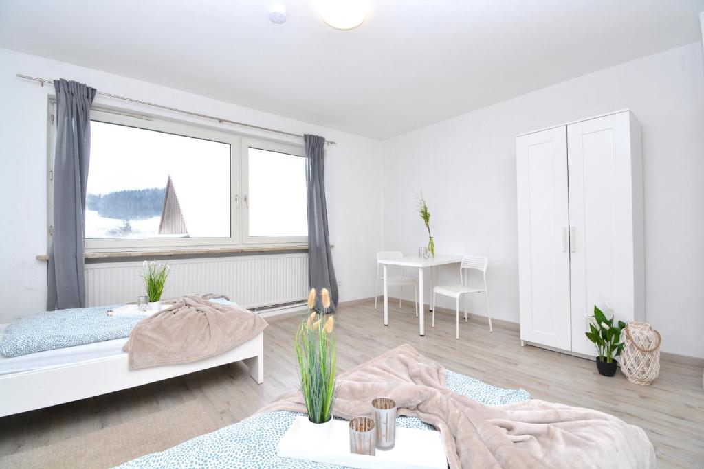 ein weißes Schlafzimmer mit einem Bett und einem Fenster in der Unterkunft CO02-HI Apartment in Coburg in Coburg