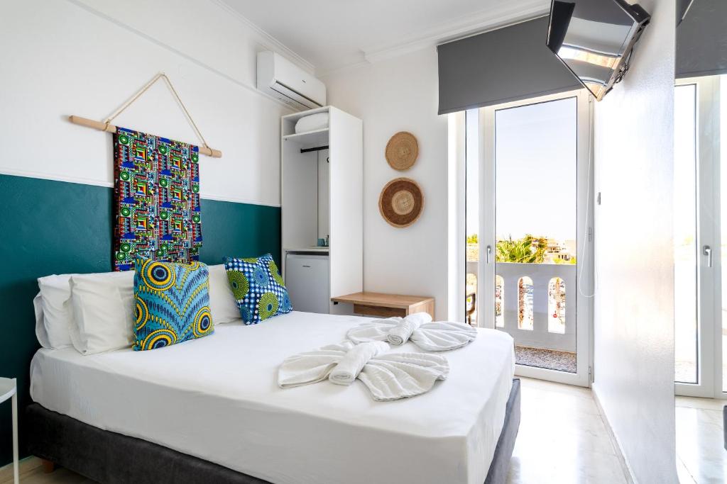 a bedroom with a large white bed and a window at Kumba At Koum Kapi in Chania