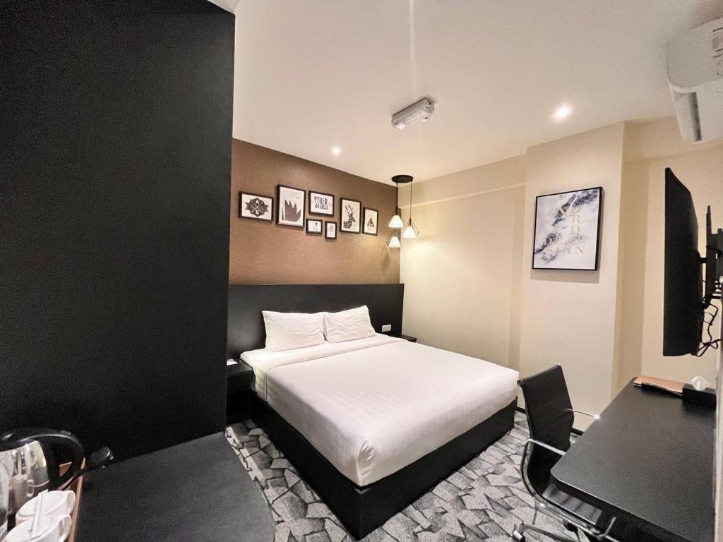 een slaapkamer met een wit bed en een bureau bij Hotel Aman Kuala Lumpur in Kuala Lumpur