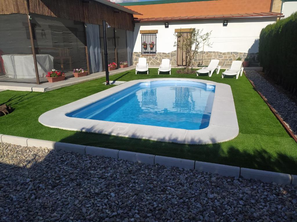 einen Pool in einem Garten mit Gras in der Unterkunft Casa Rural VUT El Rincón de Eulogio in El Torno