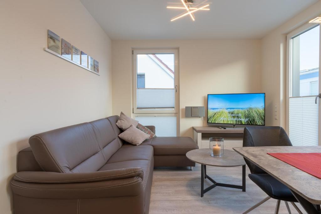 a living room with a couch and a tv at Fewo Schröder - Tolle in Norderney
