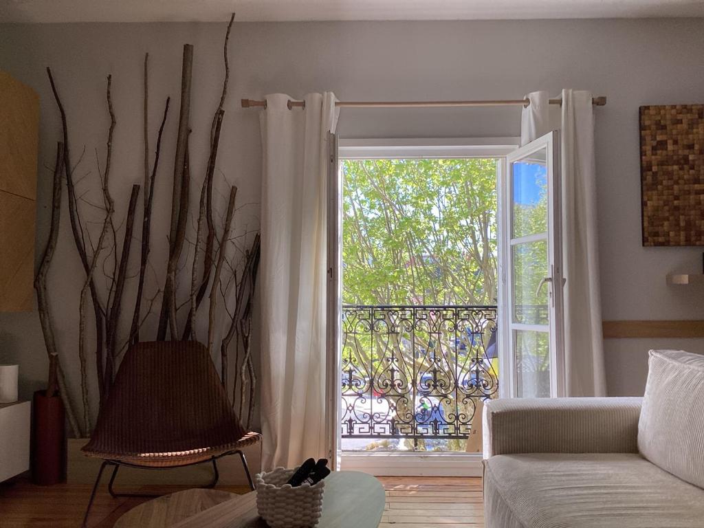 d'un salon avec une porte s'ouvrant sur un balcon. dans l'établissement Arcachon, à Arcachon