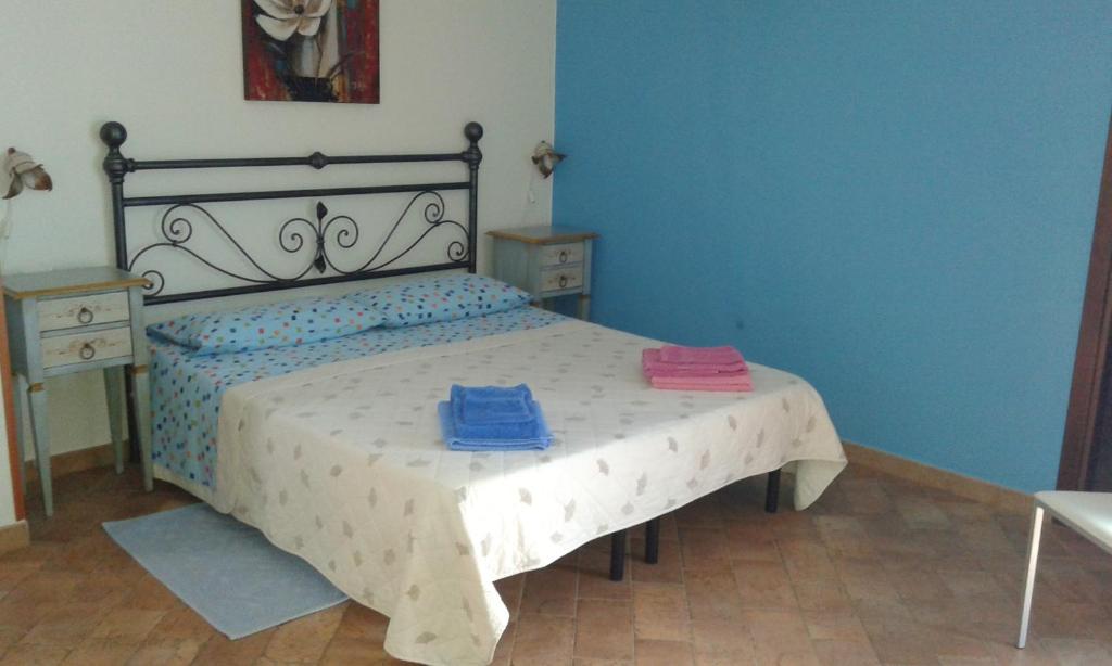 1 dormitorio con 1 cama con 2 toallas en B&b Su Acu, en Dorgali