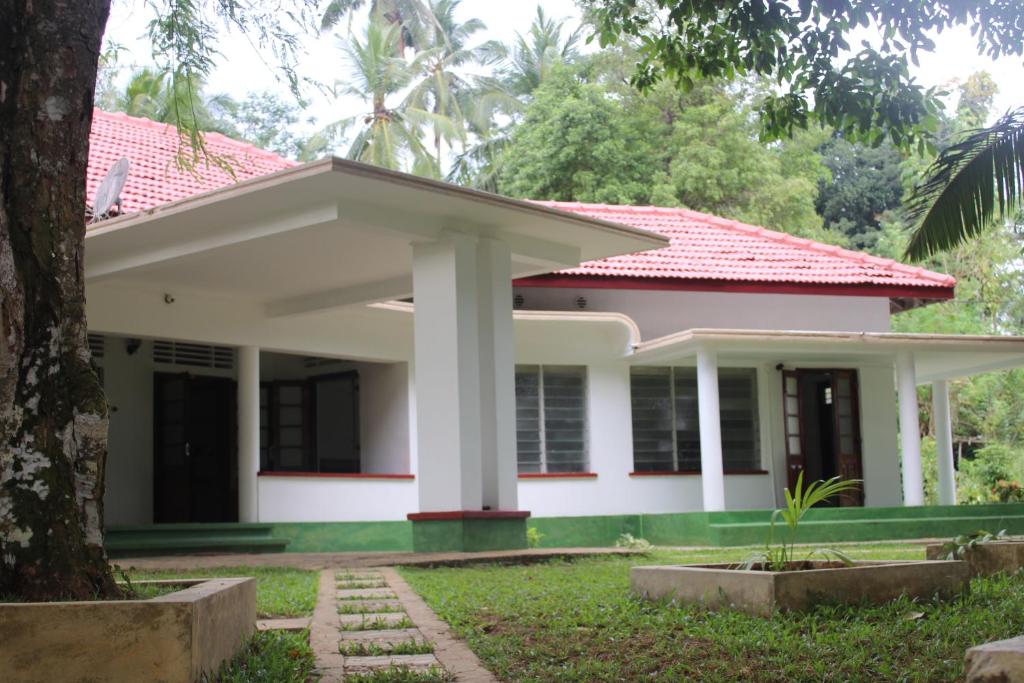 a white house with a red roof at DUTCH BUNGALOW galle in Imaduwa