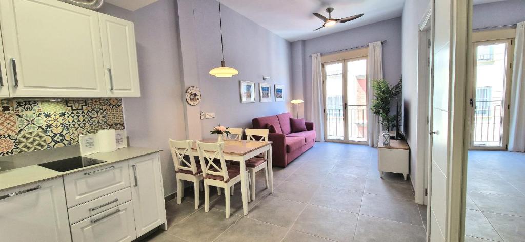 cocina y sala de estar con mesa y sofá en Malaga Lodge Apartments en Málaga