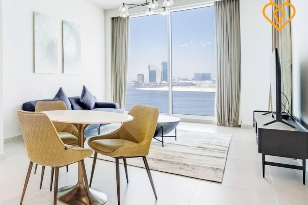 a living room with a table and chairs at Keysplease Spectacular Views Modern 1BR Creek Gate 602 in Dubai