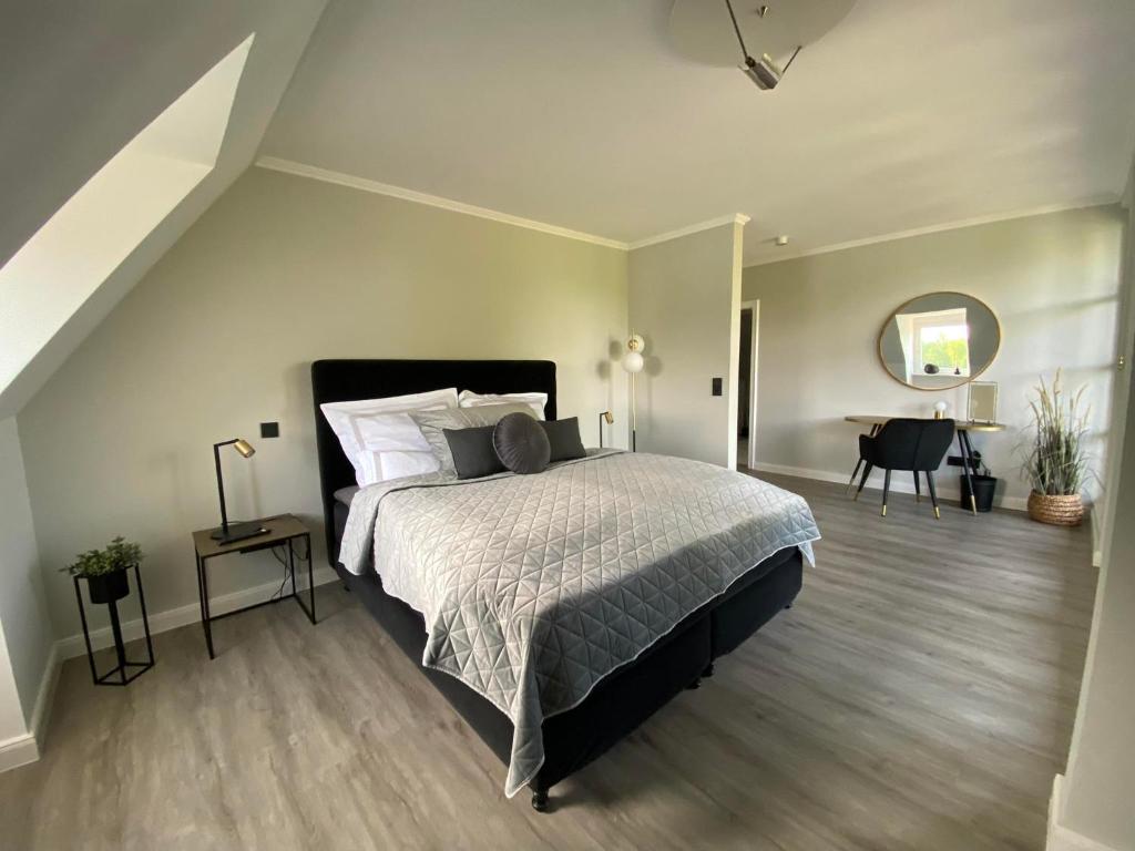 sypialnia z dużym łóżkiem i biurkiem w obiekcie Landhaus Lotten w mieście Winsen (Luhe)