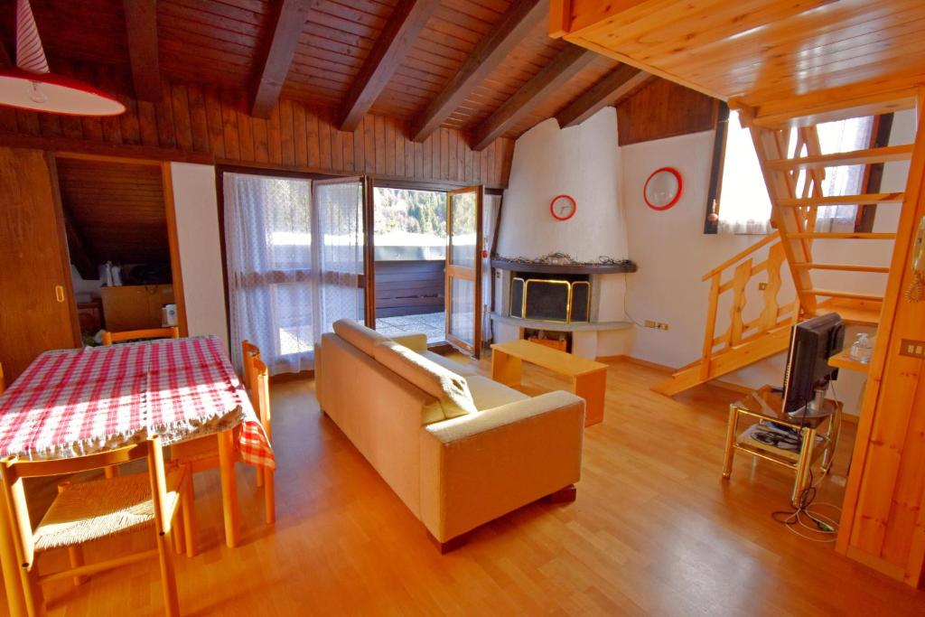 ein Wohnzimmer mit einem Sofa und einem Kamin in der Unterkunft MASO Trilocale con terrazze in Madonna di Campiglio