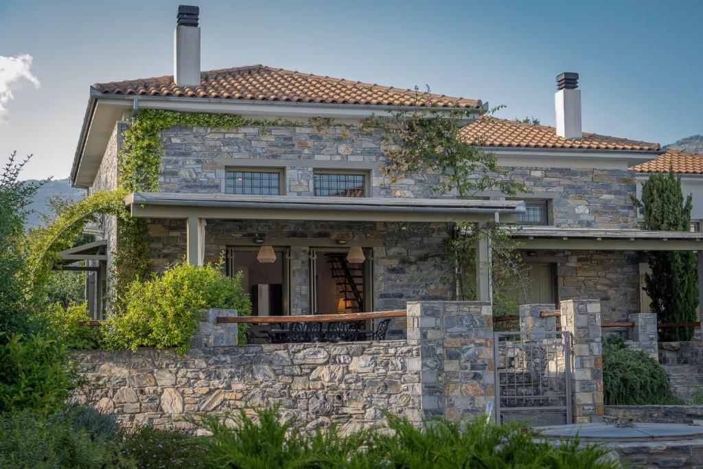 une maison en pierre avec un mur en pierre dans l'établissement Villa Jasmine, à Platanidia