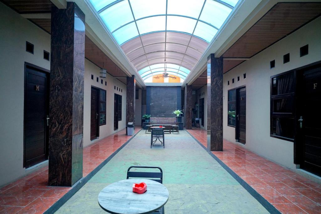 a hallway with a table and a glass ceiling at RedDoorz Syariah near Unila in Bandar Lampung