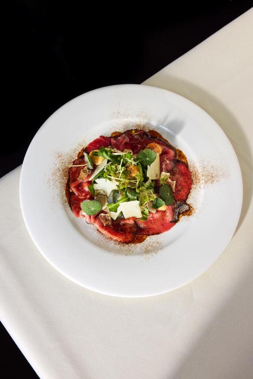 a small pizza on a white plate on a table at Château Gütsch in Luzern