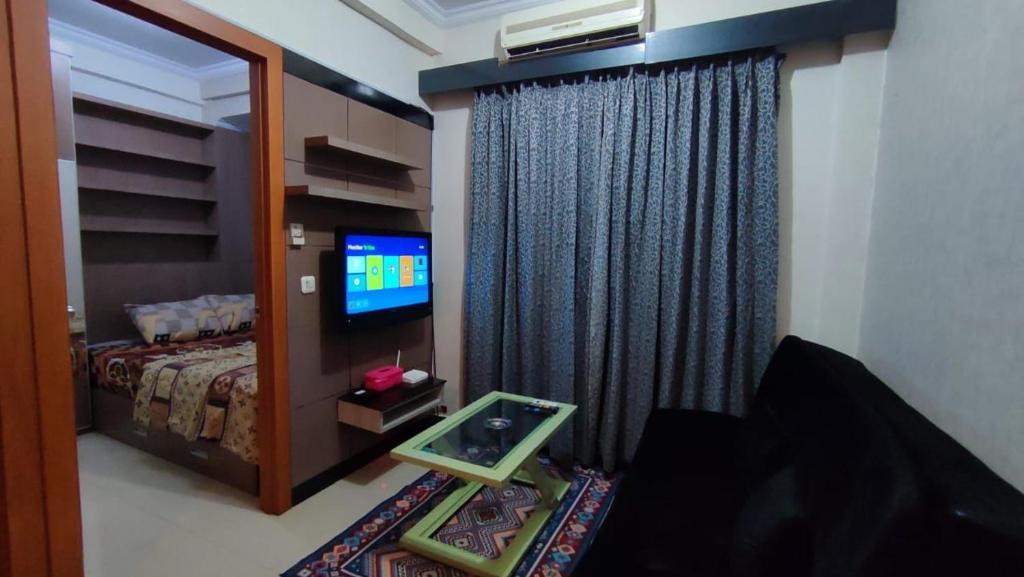 - une chambre avec un lit, une télévision et une fenêtre dans l'établissement OKA ROOM, à Kayuringin