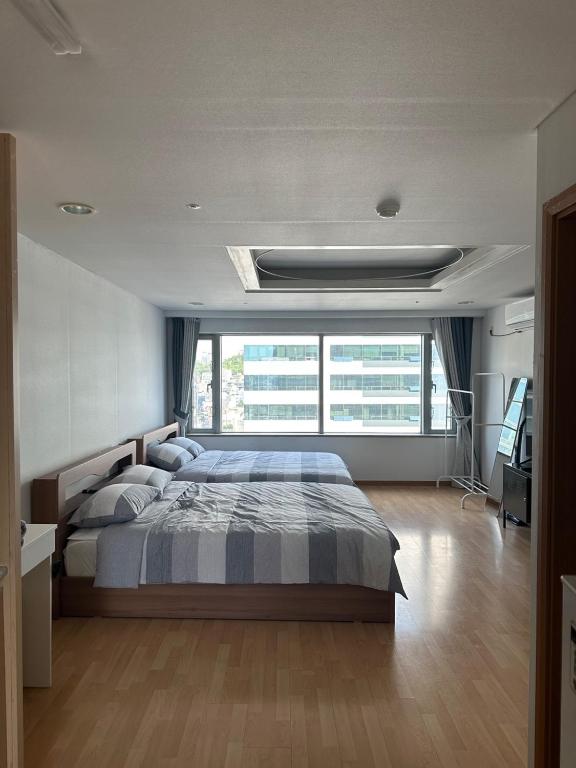 a bedroom with a bed and a large window at Hongdae Guesthouse 1min from Hongik Uni station Exit #1 in Seoul