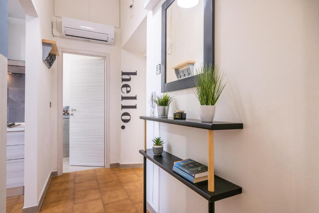 a hallway with a staircase with a table and plants at Travel Station Apartment by Pleiades Home in Livorno