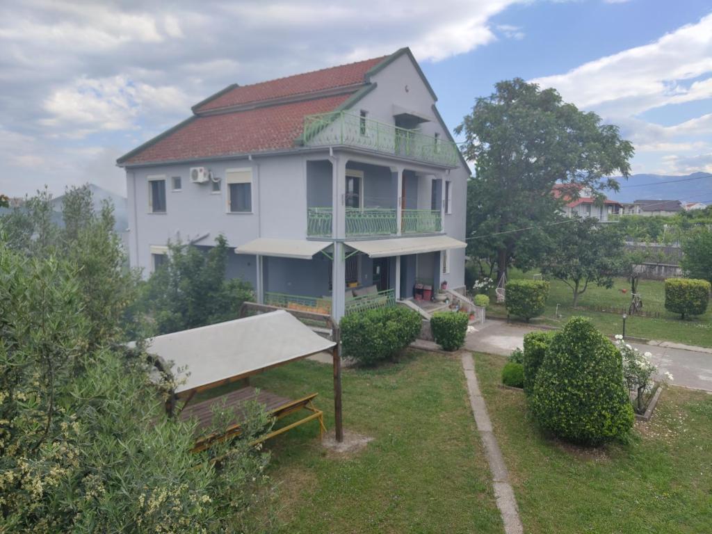 una casa blanca con un banco delante en Green Garden Guesthouse en Shkodër