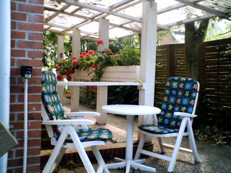 twee stoelen en een tafel onder een pergola bij Haus-Halliger-Appartment-Ilse in Westerland