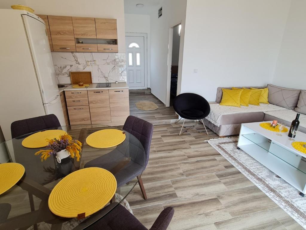 sala de estar con sofá, mesa y sillas en Apartmani Jovan, en Ulcinj