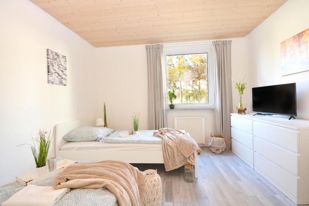 1 dormitorio con 1 cama, TV y ventana en CO05-HI Apartment in Coburg, en Coburg