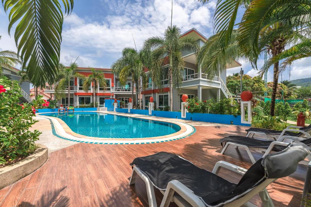 a resort swimming pool with chairs and a building at The One Cozy Vacation Residence SHA Hotel in Chalong 