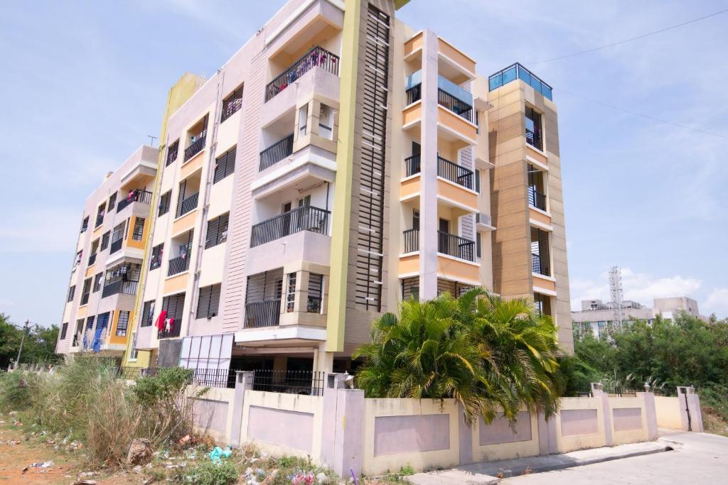 un edificio de apartamentos con una valla delante en High Point Serviced Apartment, en Tiruchchirāppalli