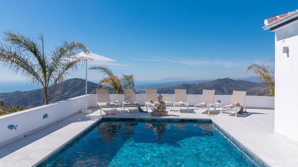 a villa with a swimming pool and mountains in the background at Villa Isabella Cómpeta by Ruralidays in Cómpeta