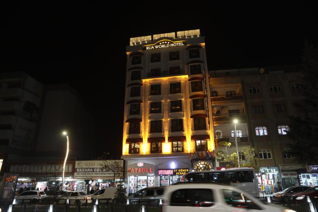 a building with a sign on top of it at night at RUA WORLD HOTEL in Bostaniçi