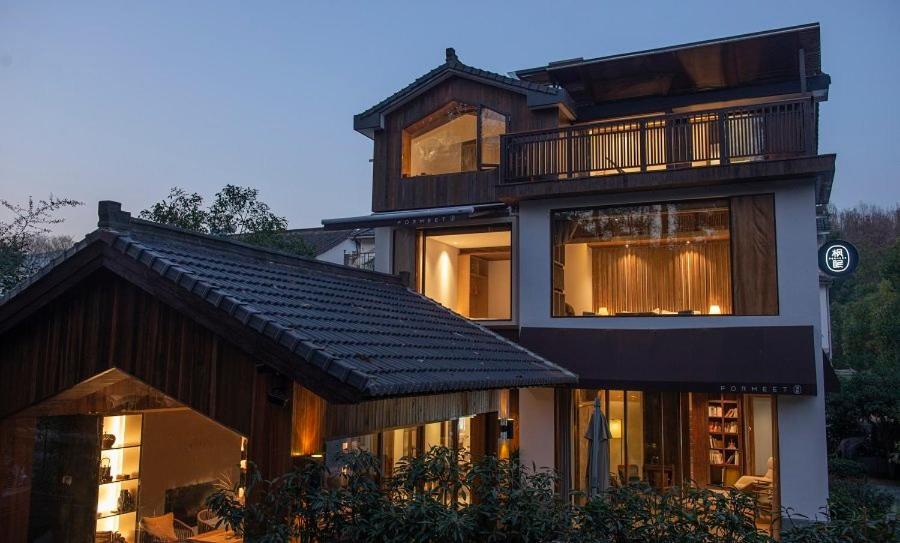 uma casa grande com uma varanda em cima em Formeet Boutique Homestay em Hangzhou