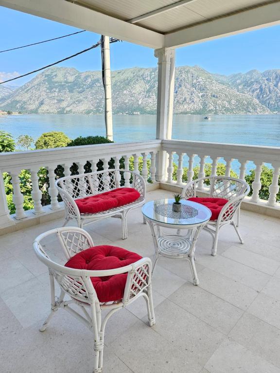 - une terrasse couverte avec des chaises et des tables offrant une vue sur l'eau dans l'établissement Apartments Popovic, à Kotor