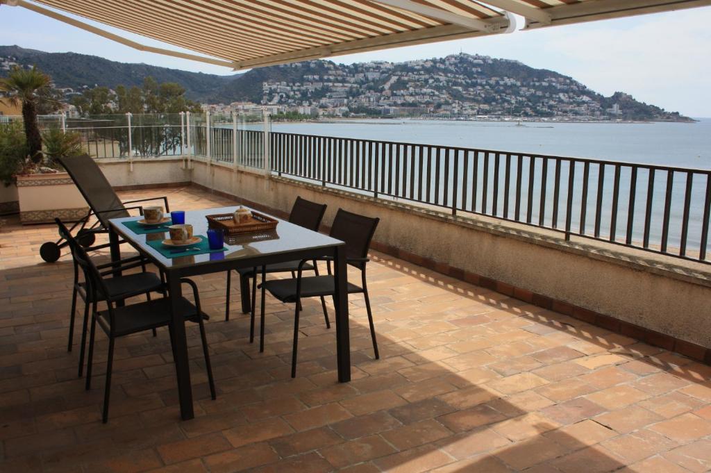 ロザスにあるGMID IMMO Apartamento Castell Joncar 3のテーブルと椅子、水辺の景色を望むバルコニー