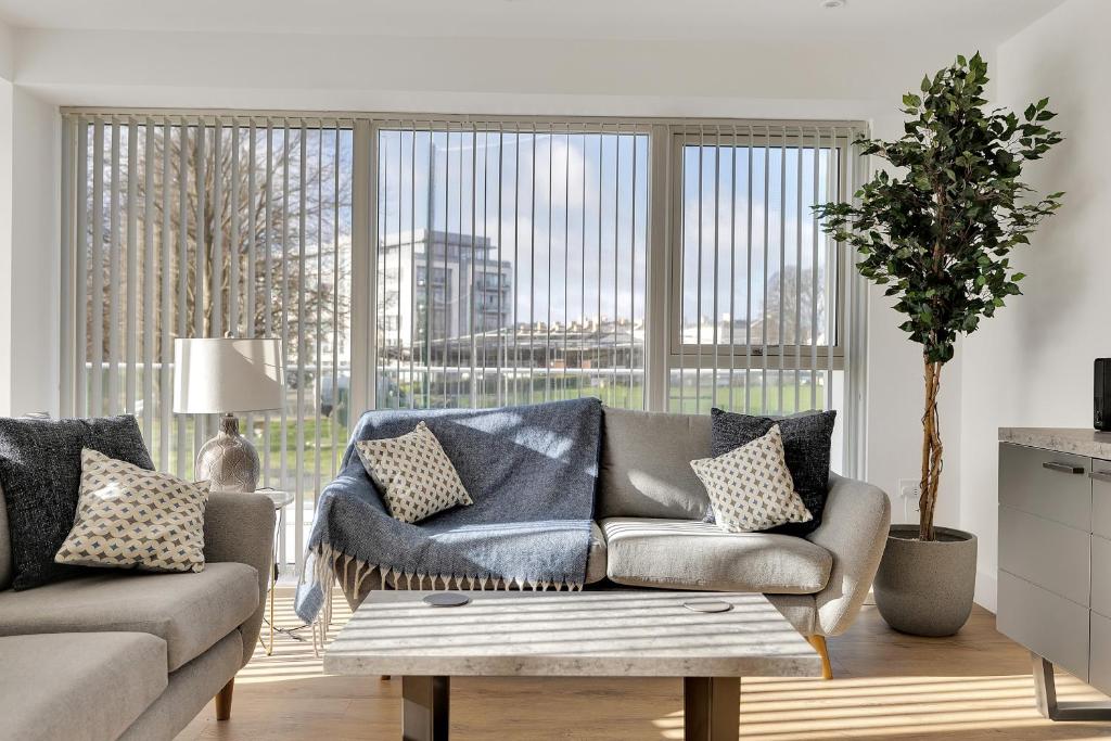 a living room with a couch and a large window at 3 Bed- The Pavilion By Pureserviced in Plymouth