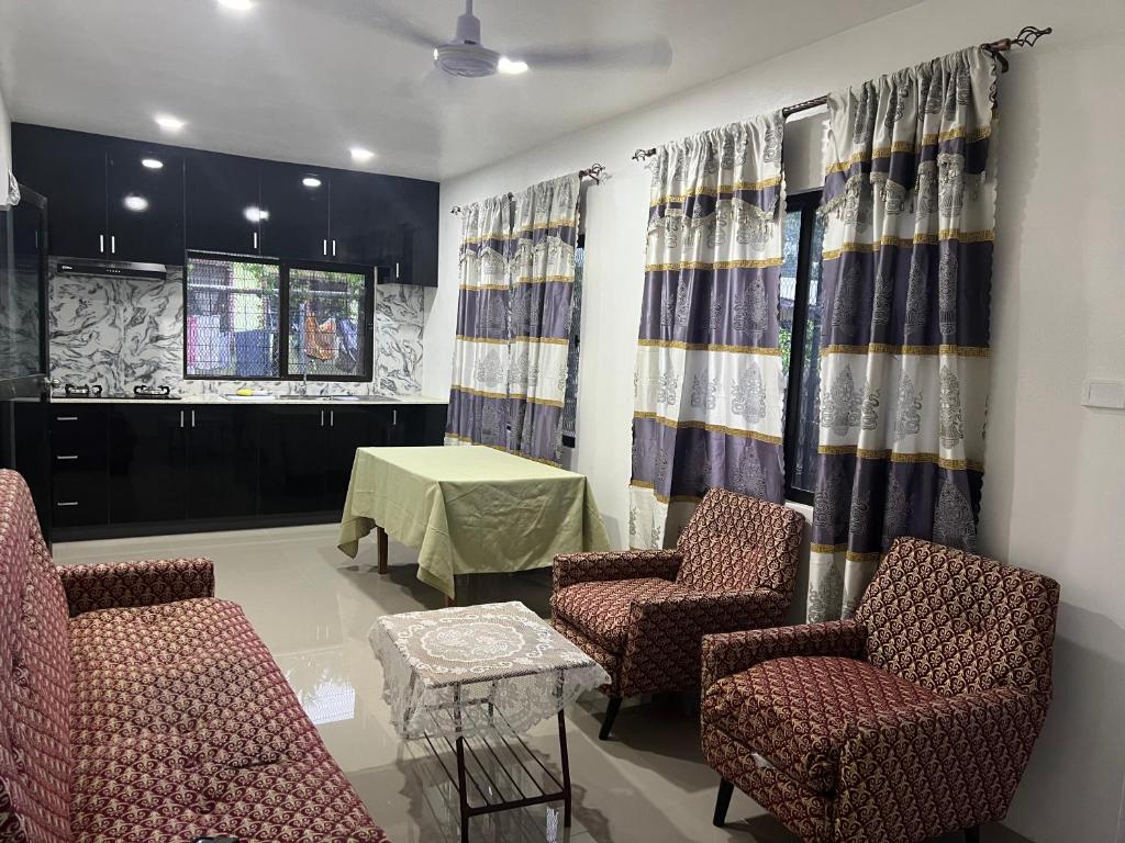 uma sala de espera com cadeiras, uma mesa e cortinas em Island Guesthouse - entire one bedroom unit with kitchen & a bathroom centrally located in Votualevu em Nadi