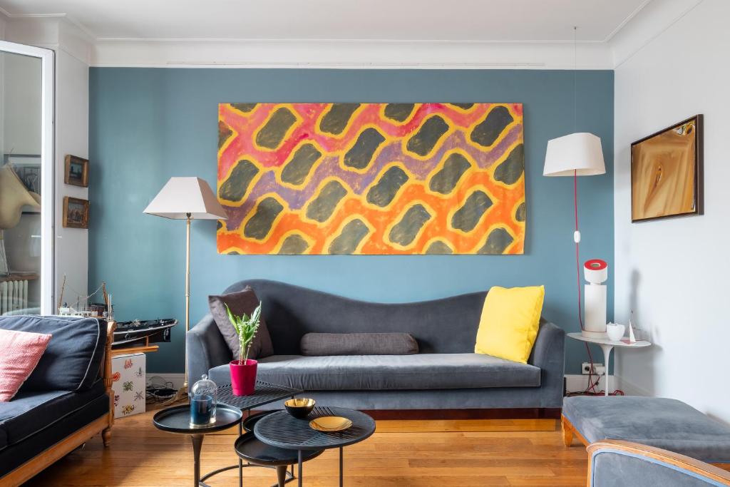 un salon avec un canapé et un tableau au mur dans l'établissement Veeve - Montmartre Majestique, à Paris