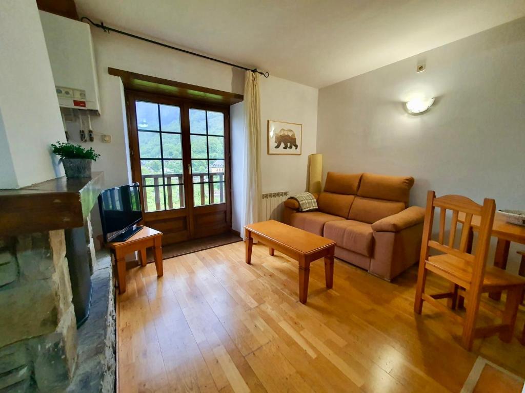 uma sala de estar com um sofá e uma mesa em VIelha V em Vielha