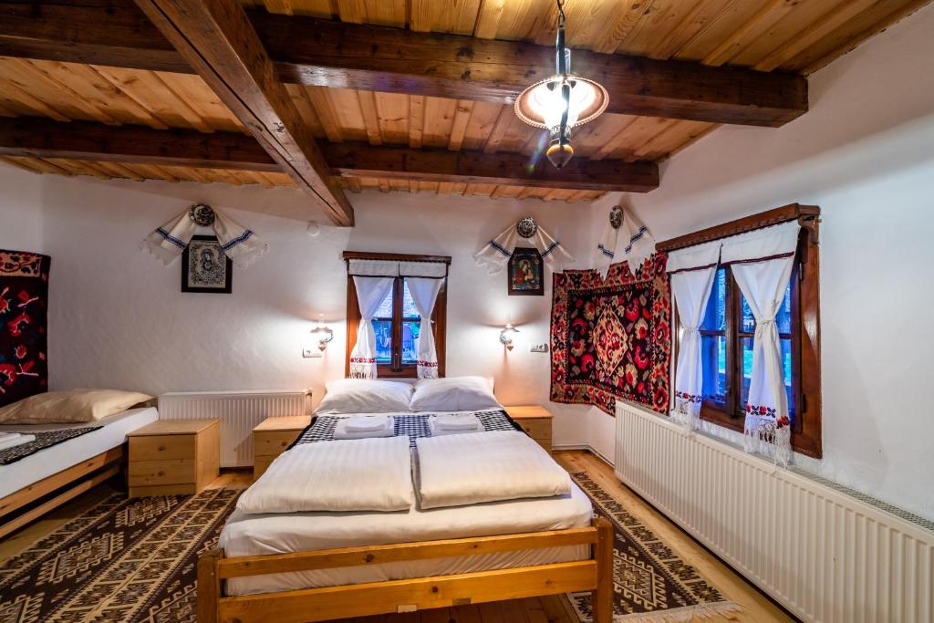 a bedroom with two beds and two windows at Pensiunea Marioara in Breb