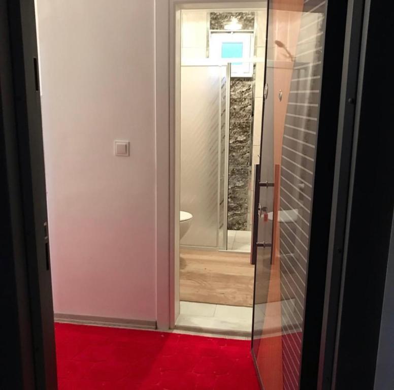 d'une porte en verre menant à une salle de bains pourvue d'un tapis rouge. dans l'établissement Atakum Körfez Yat Limanı,Marina 20 Metre,Denize kolay ulaşım,Merkezi, à Atakum