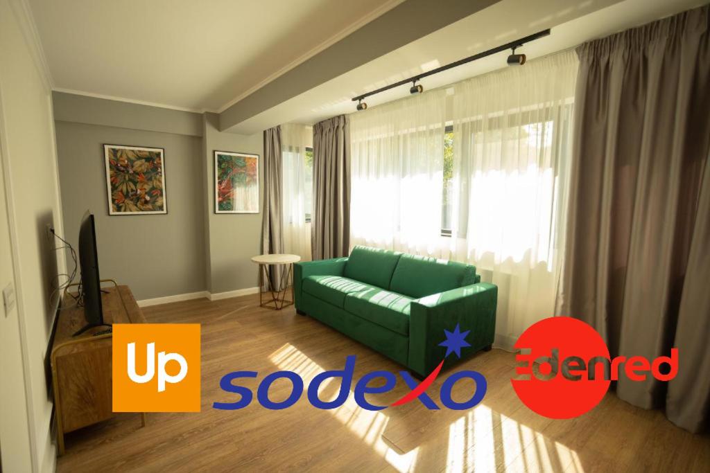 een woonkamer met een groene bank voor een raam bij Oliv Residence in Iaşi
