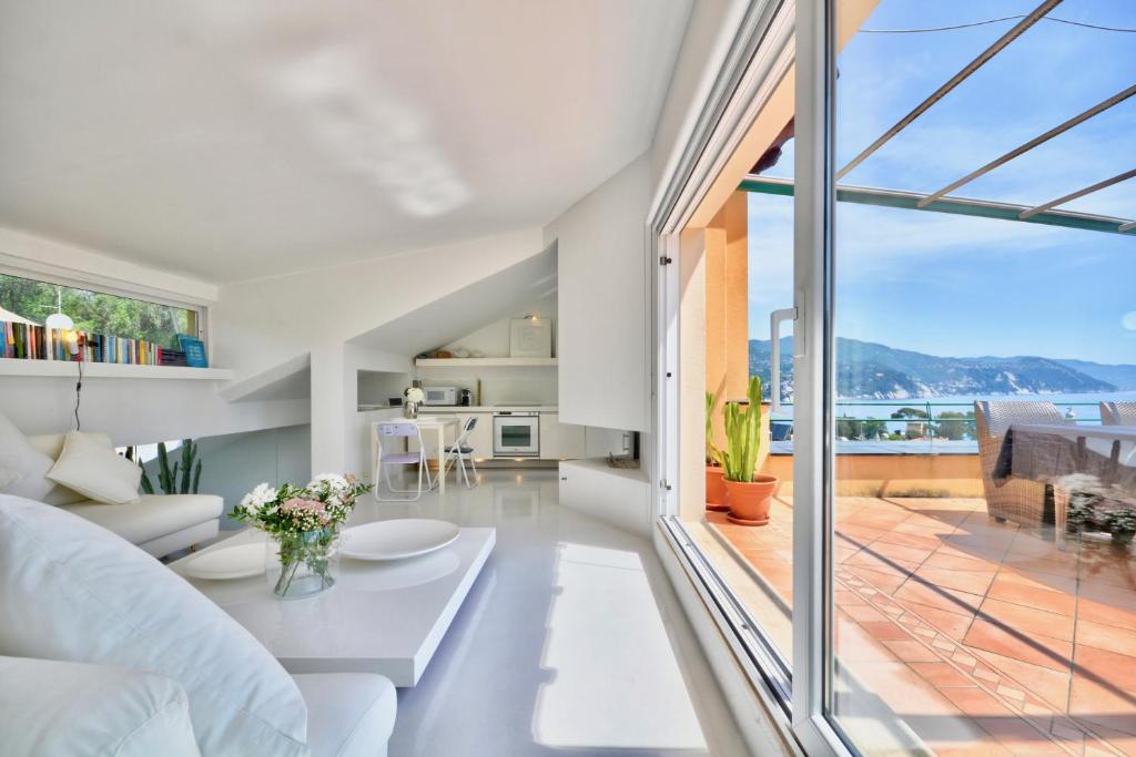 ein Wohnzimmer mit einem weißen Sofa und einem großen Fenster in der Unterkunft Penthouse Marina-Seaview Jacuzzi and Terrace in Rapallo