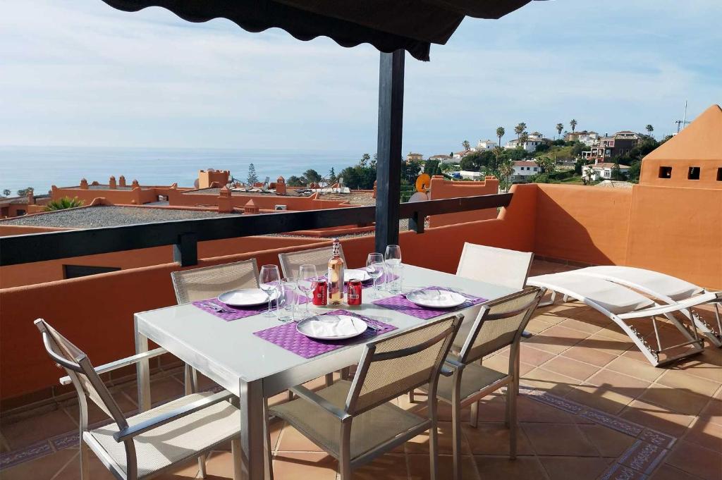 Biały stół i krzesła na balkonie z widokiem w obiekcie Jardines de Nueva Galera w mieście Estepona