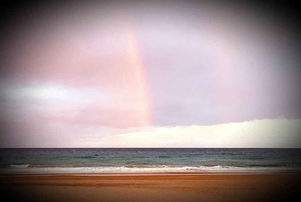 un arco iris en el cielo sobre una playa con el océano en Villa luxueuse avec vue mer en El Campello