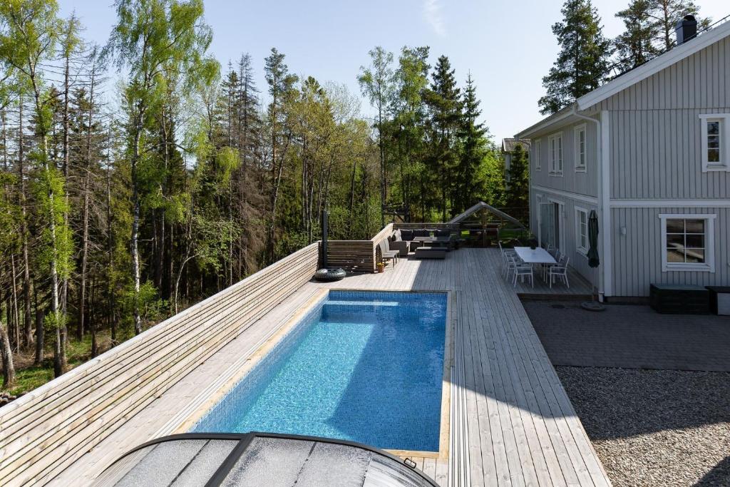 un patio trasero con piscina y una casa en Spacious accommodation near Stockholm with heated pool, 