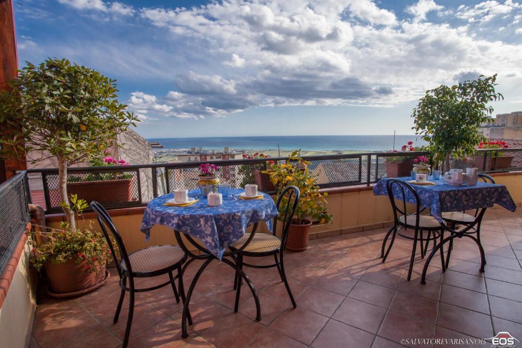 a balcony with tables and chairs and a view of the ocean at I Tetti di Girgenti in Agrigento