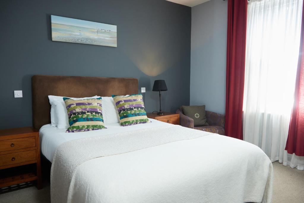 奇切斯特的住宿－Trents by Greene King Inns，卧室配有一张带白色床单和枕头的大床。