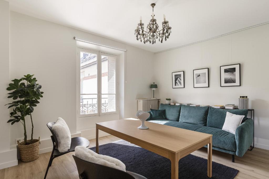 a living room with a blue couch and a table at La Savoy 2 - Thermes de Saint-Gervais - Happy Rentals in Saint-Gervais-les-Bains