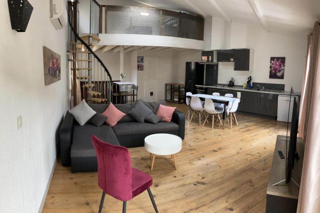 un salon avec un canapé, une table et des chaises dans l'établissement Maison de ville, à Sète