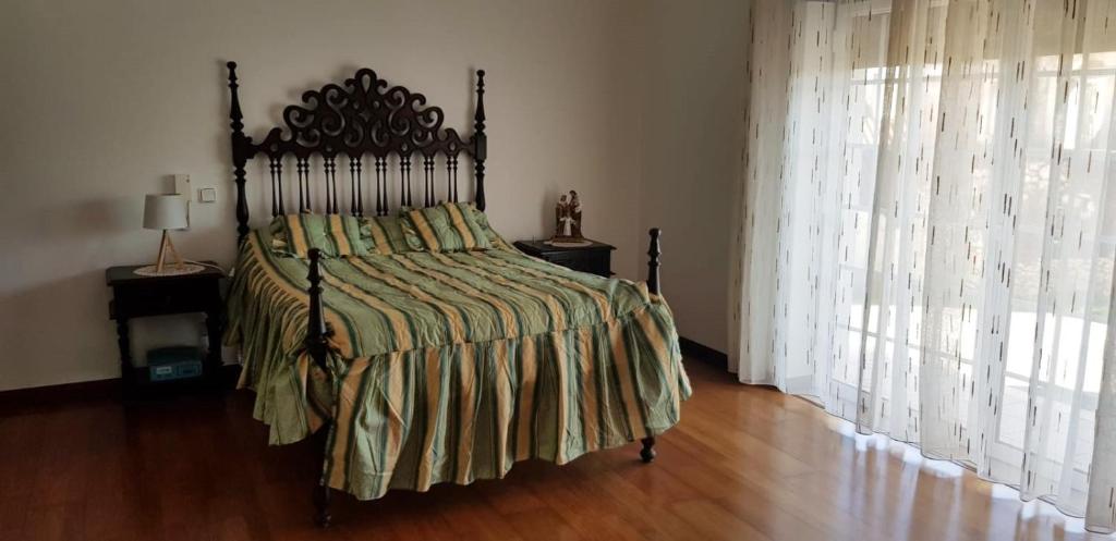 ein Schlafzimmer mit einem großen Bett und Holzboden in der Unterkunft Casa do Espinheiro in São Mamede