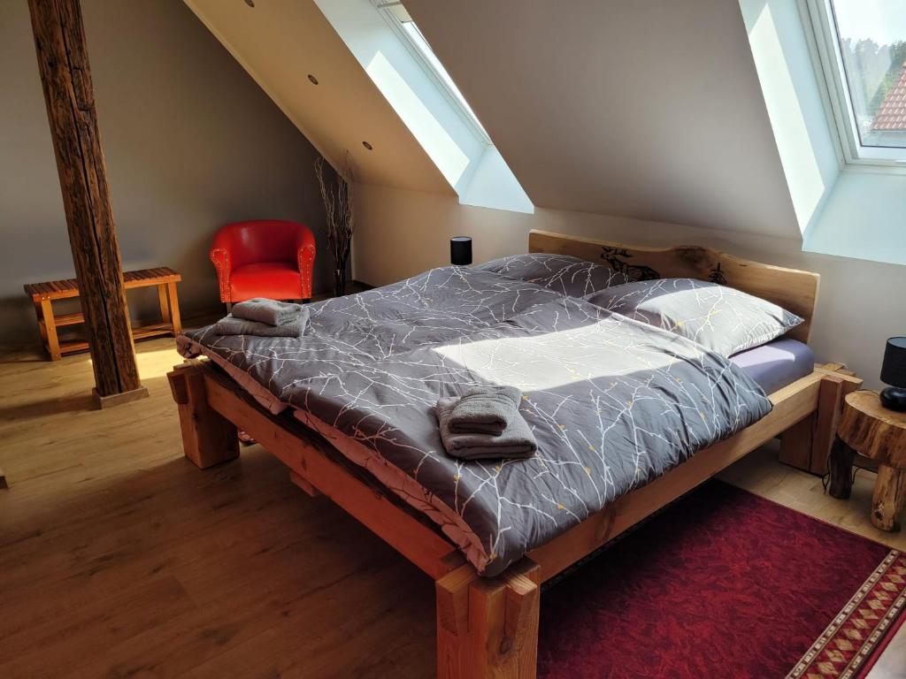 a large bed in a room with a red chair at HarzRitter Domizil in Cattenstedt