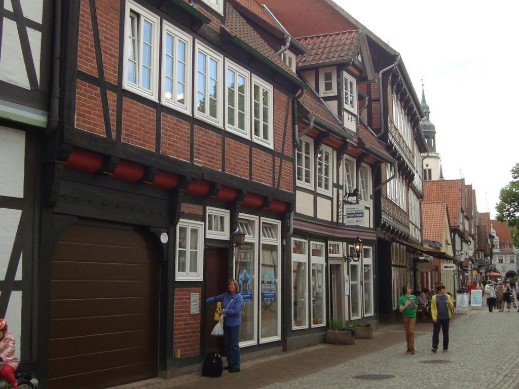 a group of people walking down a street with buildings at Wachholz, Ferienwohnung in Celle
