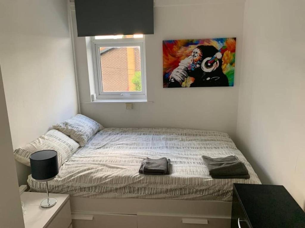 a bed in a bedroom with a picture on the wall at Cozy Room near City Centre in Manchester