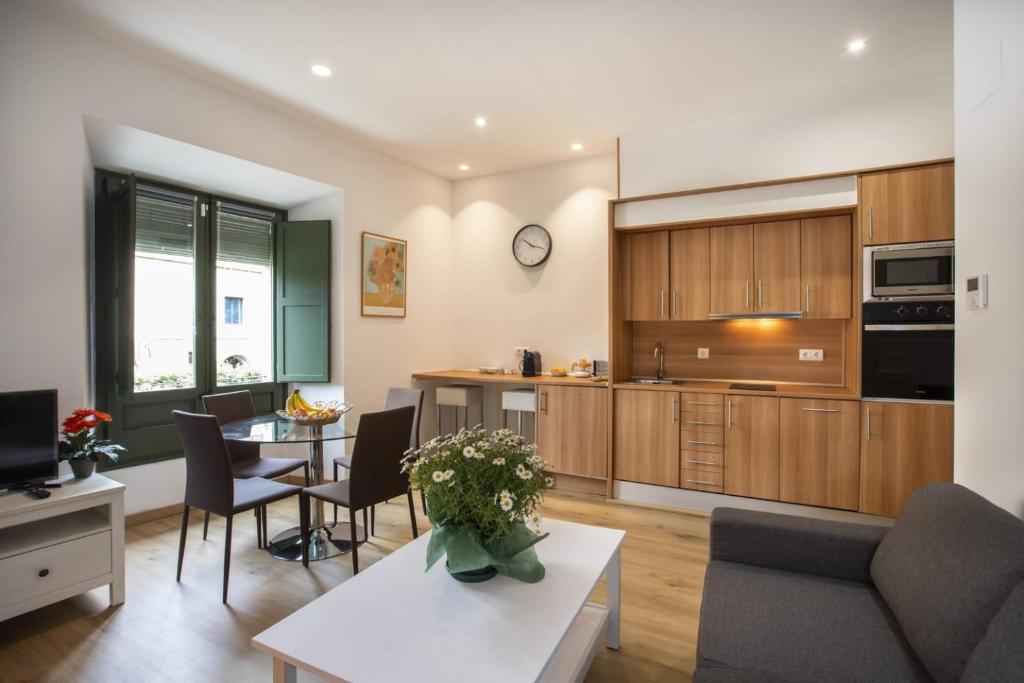a kitchen and living room with a table and chairs at Apartament al cor del barri vell de Girona in Girona
